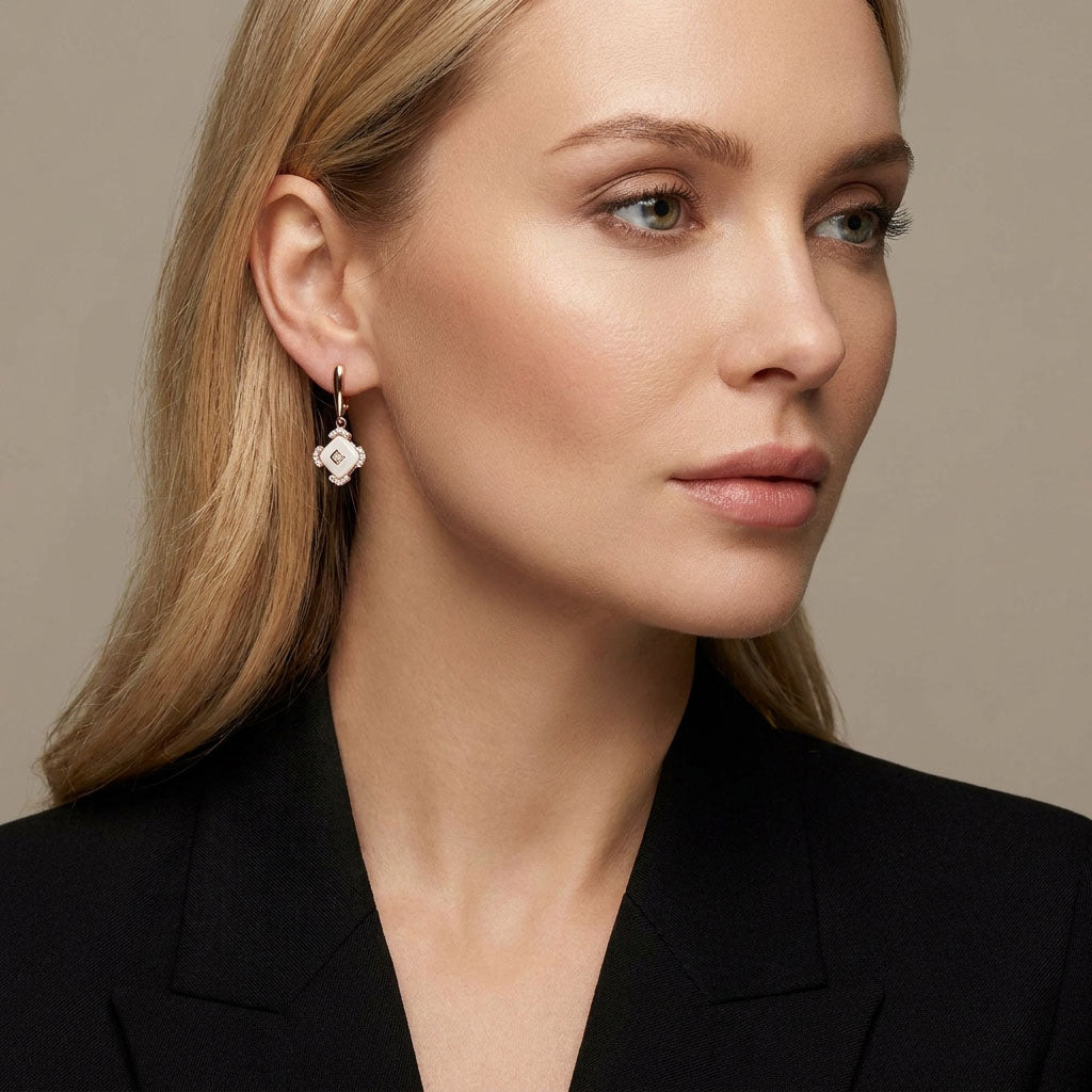 Model in a black jacket wearing a white ceramic earring with a gold-plated frame