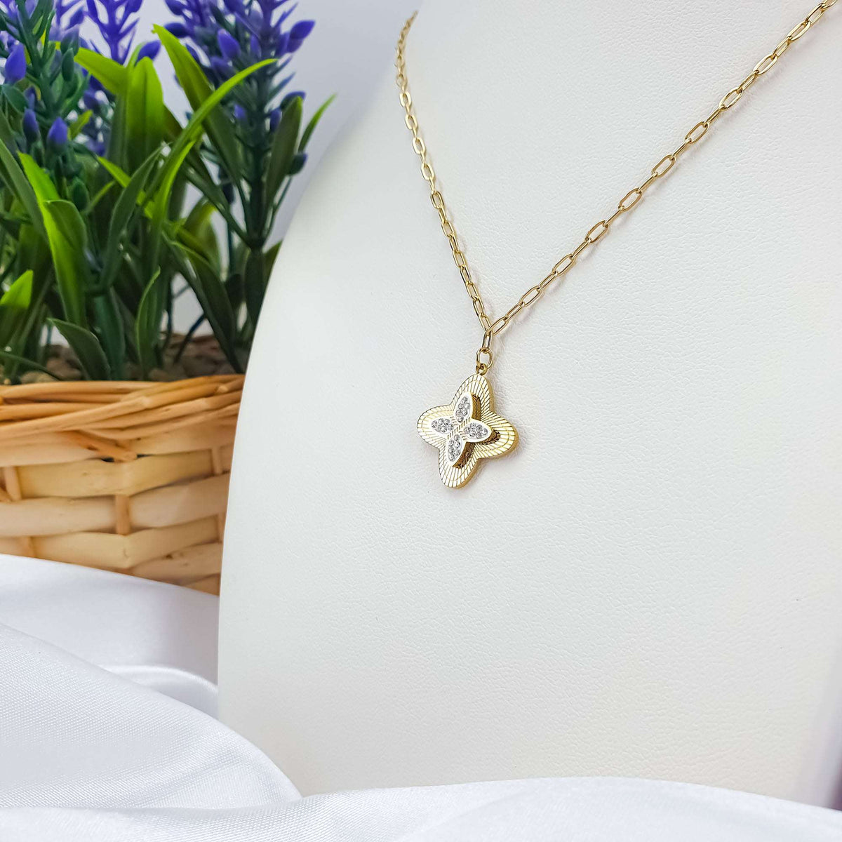 Four-leaf clover pendant with cubic zirconia on a gold-tone chain, white bust