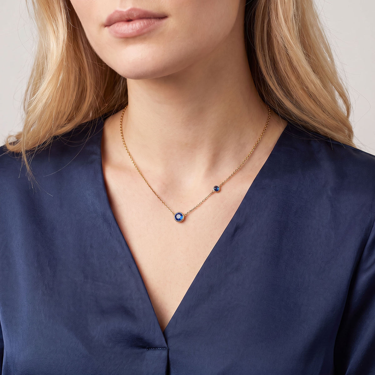 Gold-tone necklace with a blue cubic zirconia pendant
