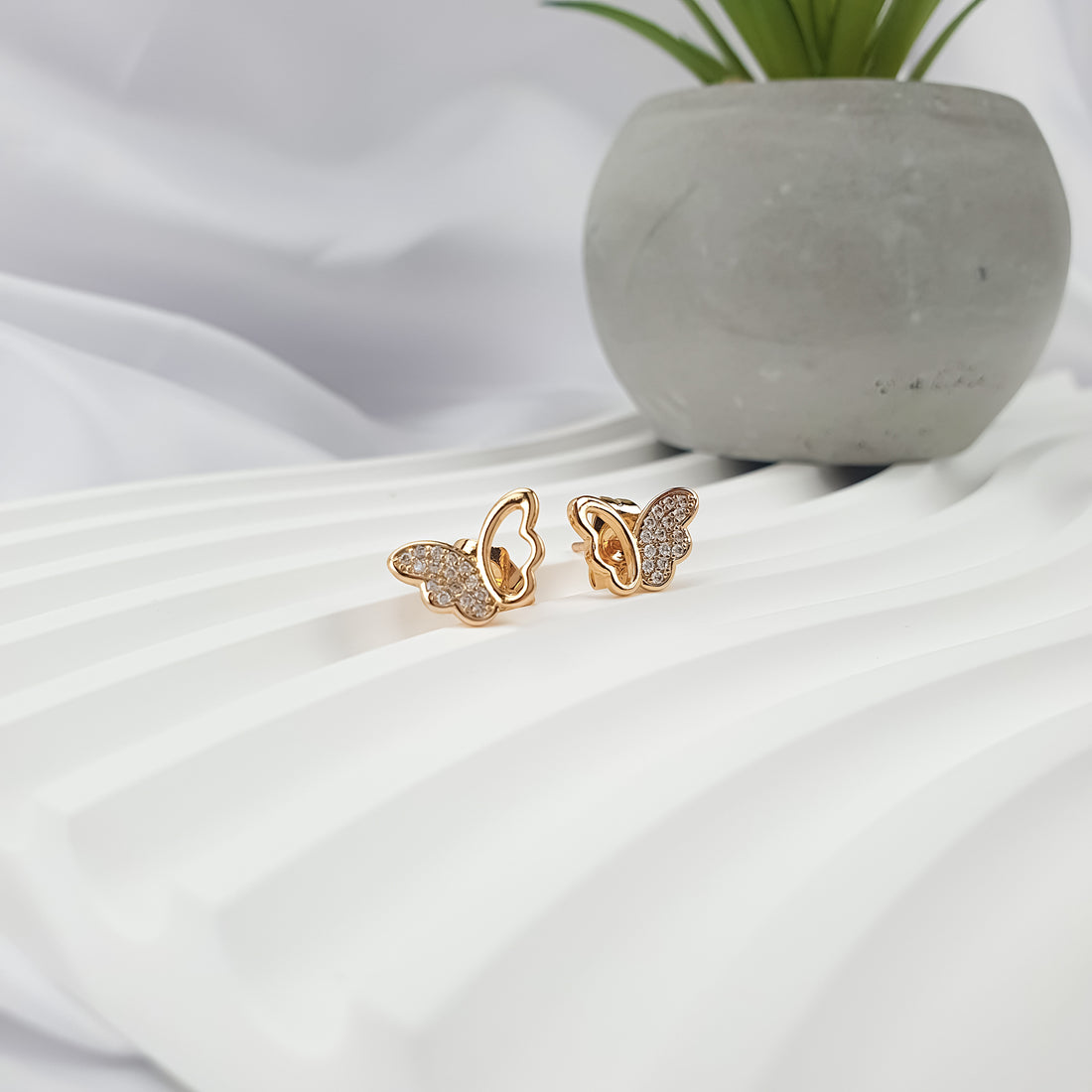 Gold-plated butterfly earrings, one wing with cubic zirconia and the other openwork