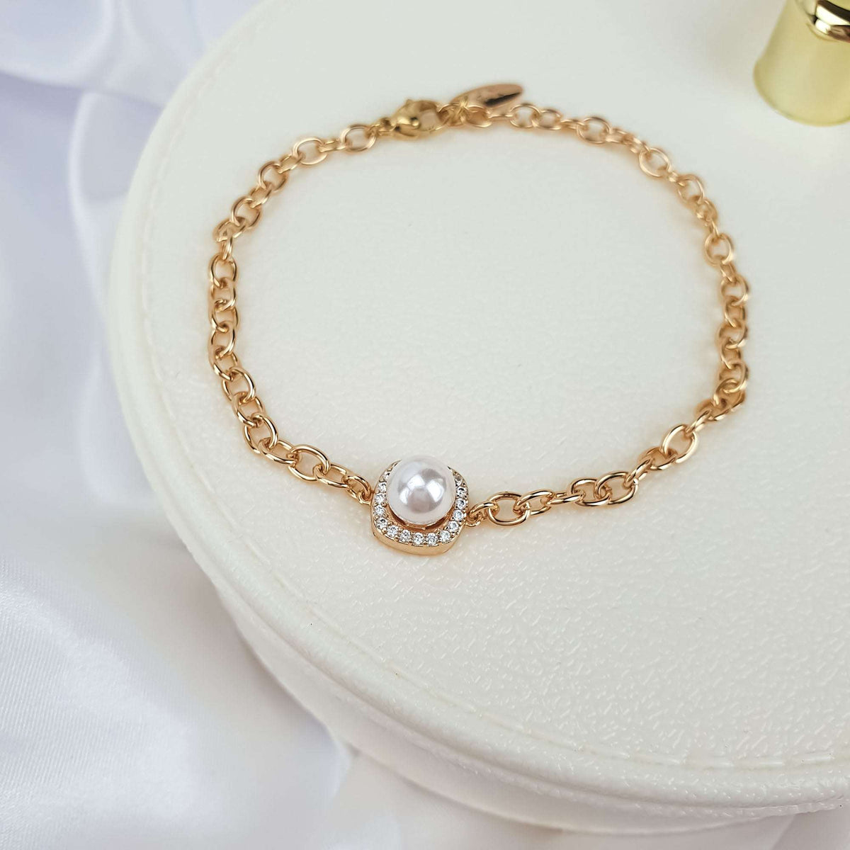 Close-up of a faux pearl in a cubic zirconia frame on a white box