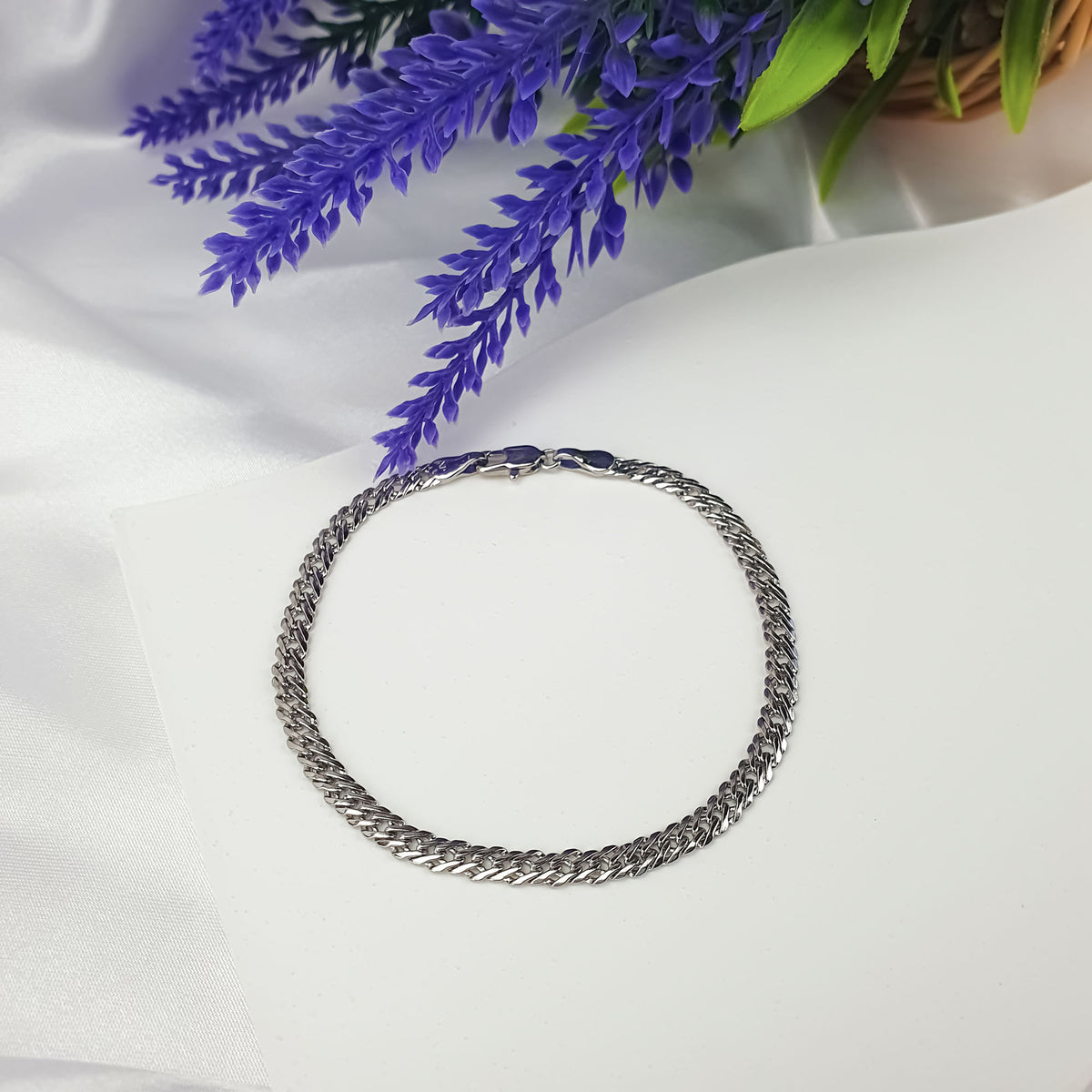 Platinum-plated bracelet on white satin with violet lavender flowers