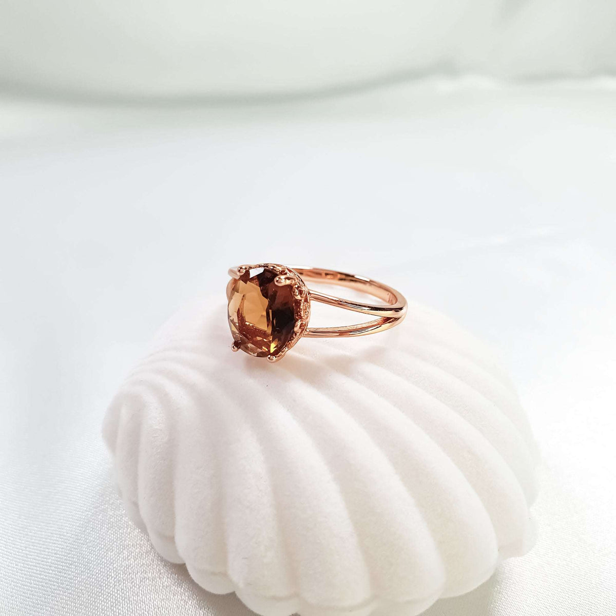 Coffee-brown cubic zirconia ring side view on white velvet