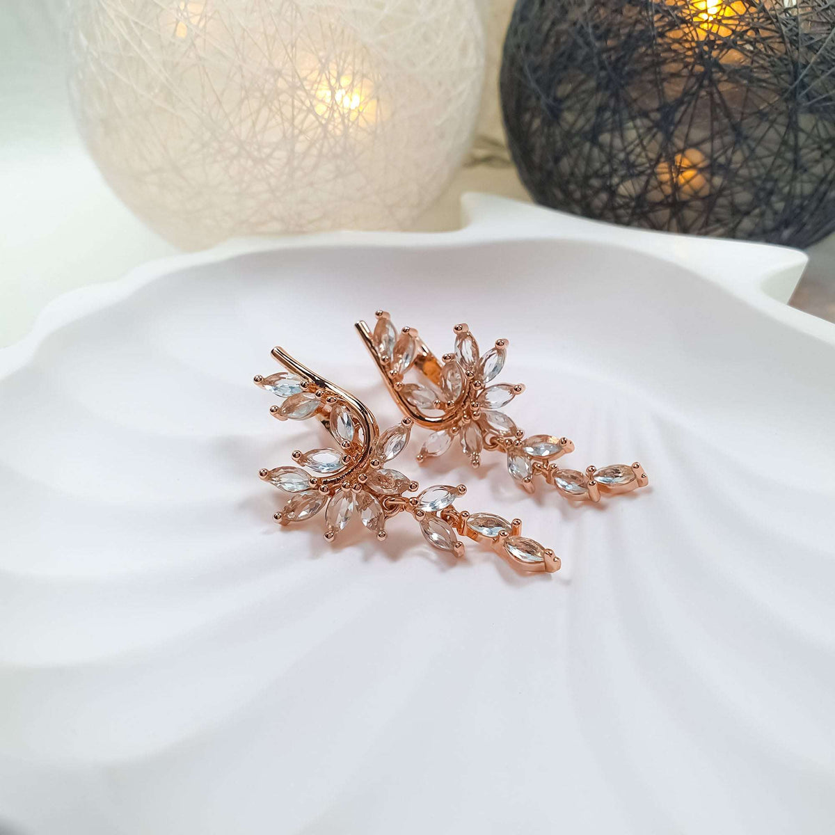 Cascading earrings with light blue marquise cubic zirconia on a white plate