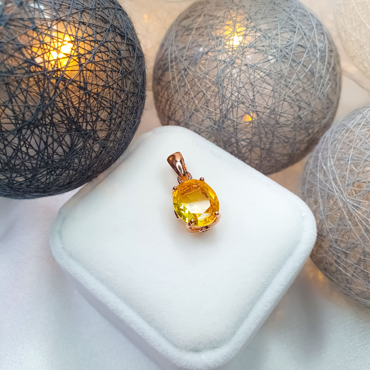 Yellow cubic zirconia pendant on a white velvet gift box