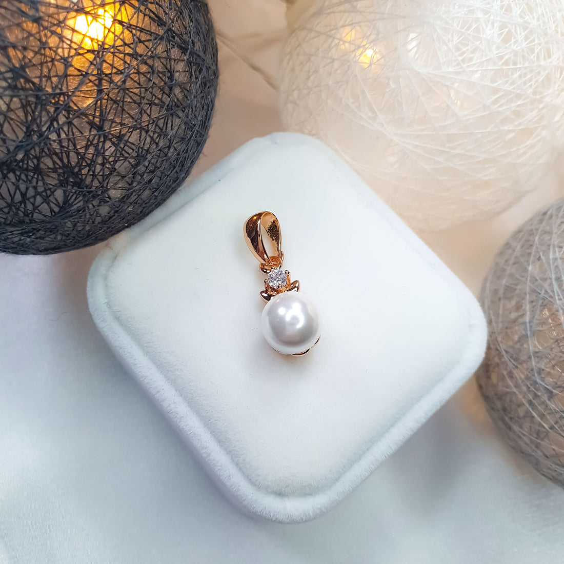 Pearl pendant with a sparkling cubic zirconia on a white velvet box