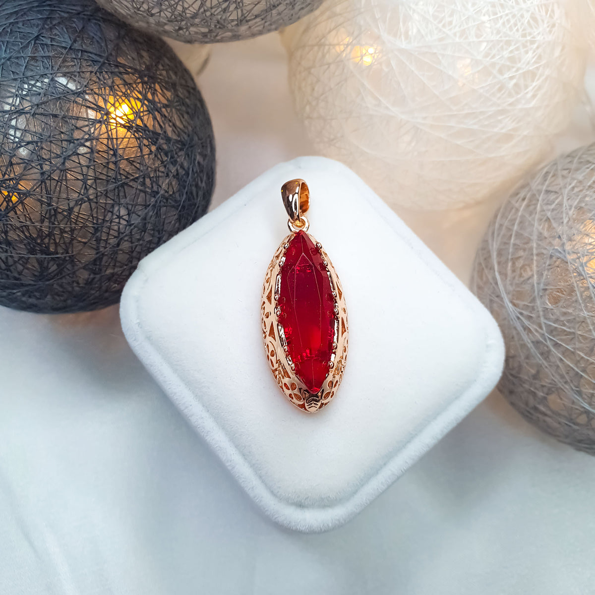 Red stone pendant with an openwork gold-tone edge in a velvet box