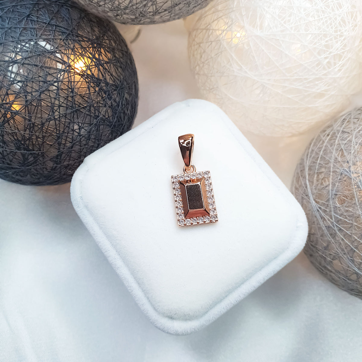 Rectangular pendant with a white cubic zirconia frame on a gift box