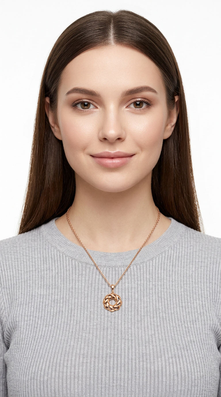 Young woman wearing the round gold-plated pendant on her chest, light studio background