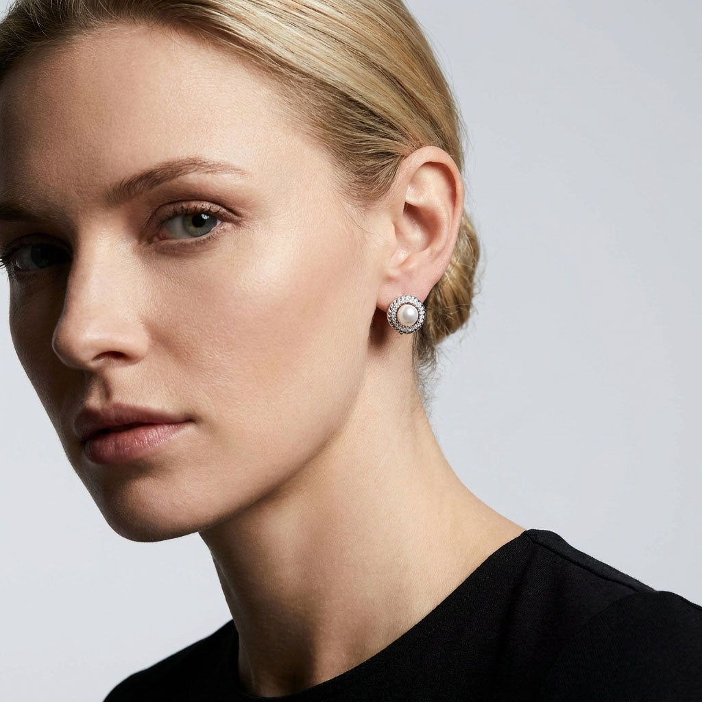 Small pearl earrings with a cubic zirconia rim on a woman's ear