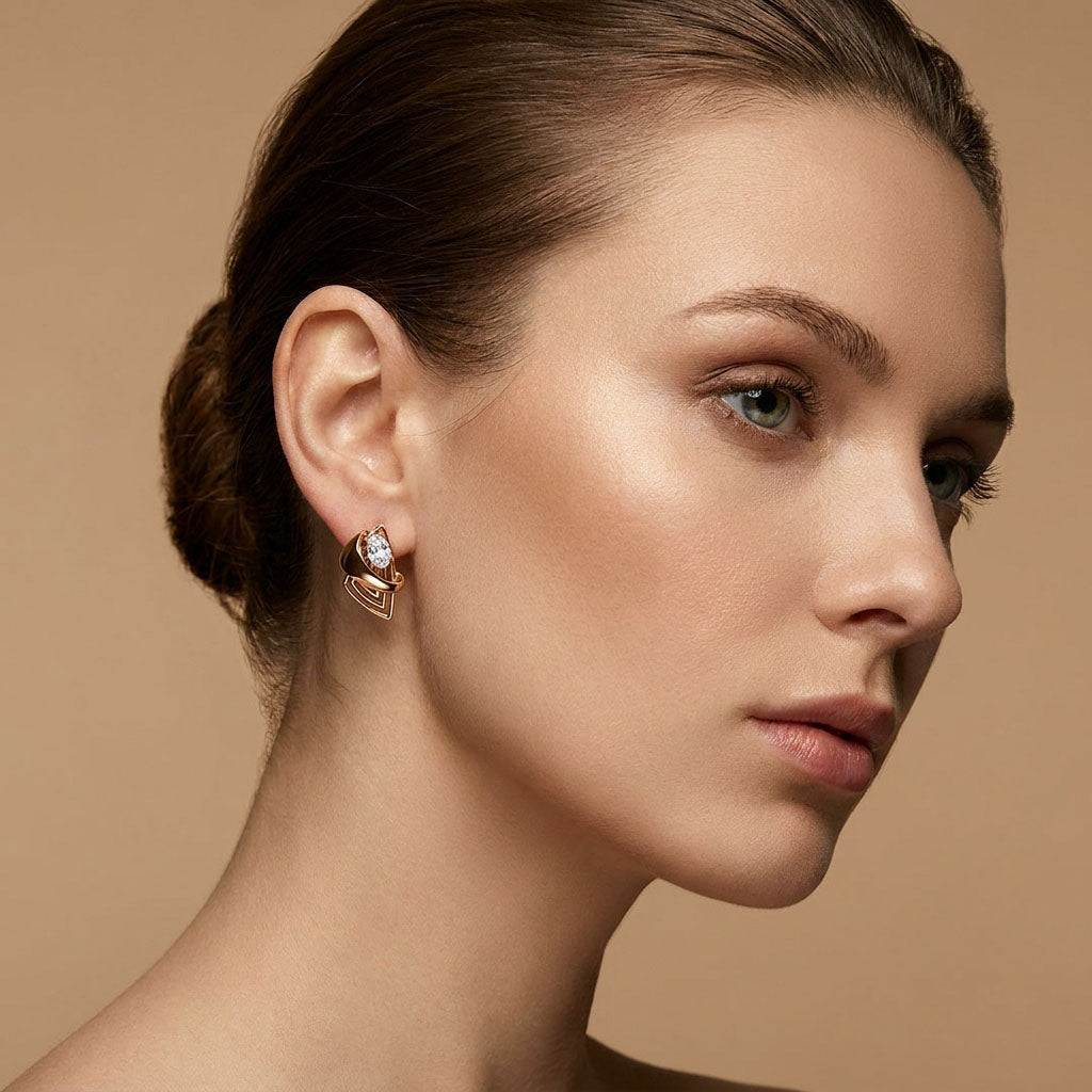 Curved-line earring with a white cubic zirconia worn by a model, warm gold tone