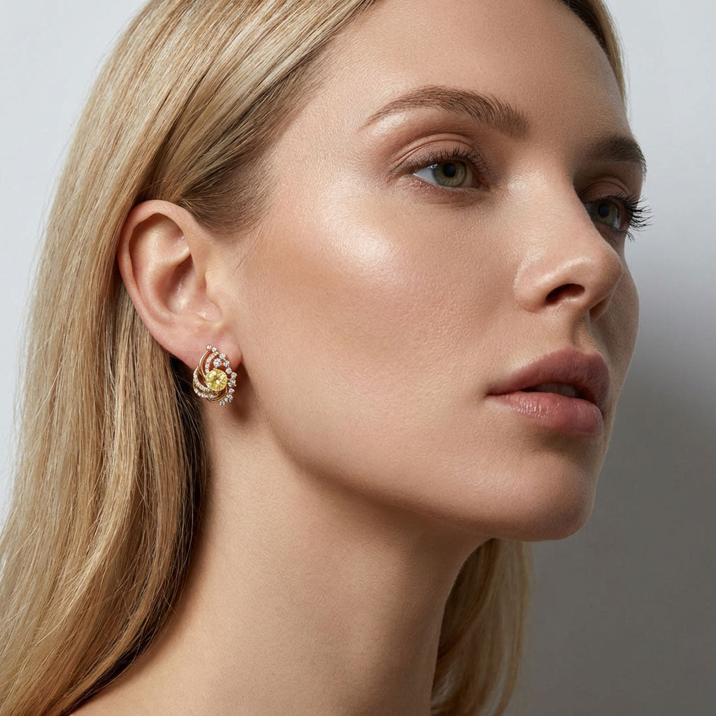 Blonde model wearing a gold-plated earring with a yellow cubic zirconia