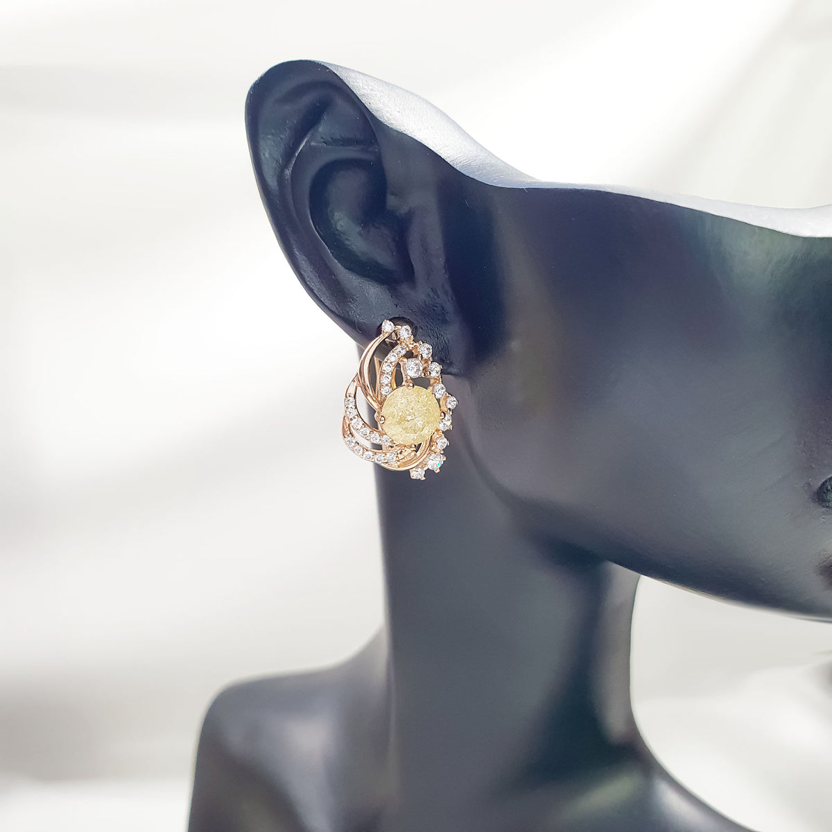 Side view of the yellow cubic zirconia earring on a black mannequin ear