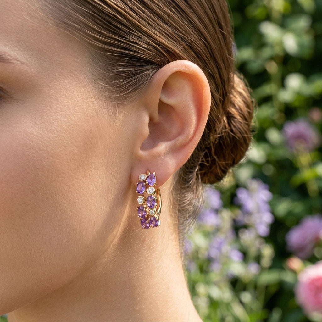 Woman in a garden wearing lilac cubic zirconia earrings, purple summer flowers behind