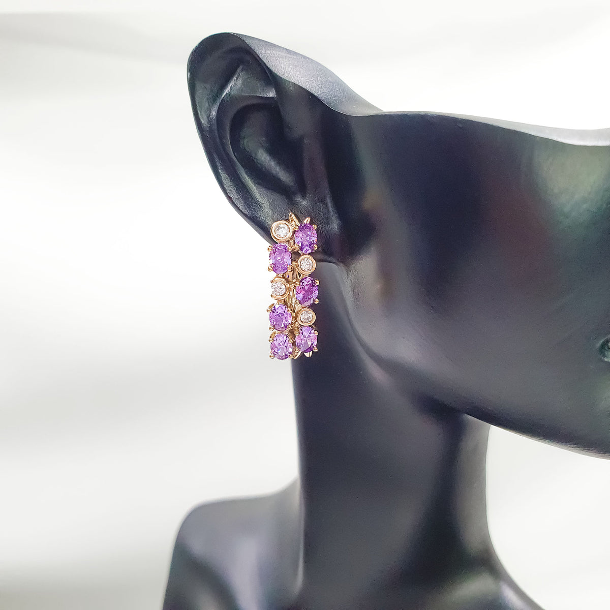 Lilac earring from the side on a dark ear model, leverback clasp visible