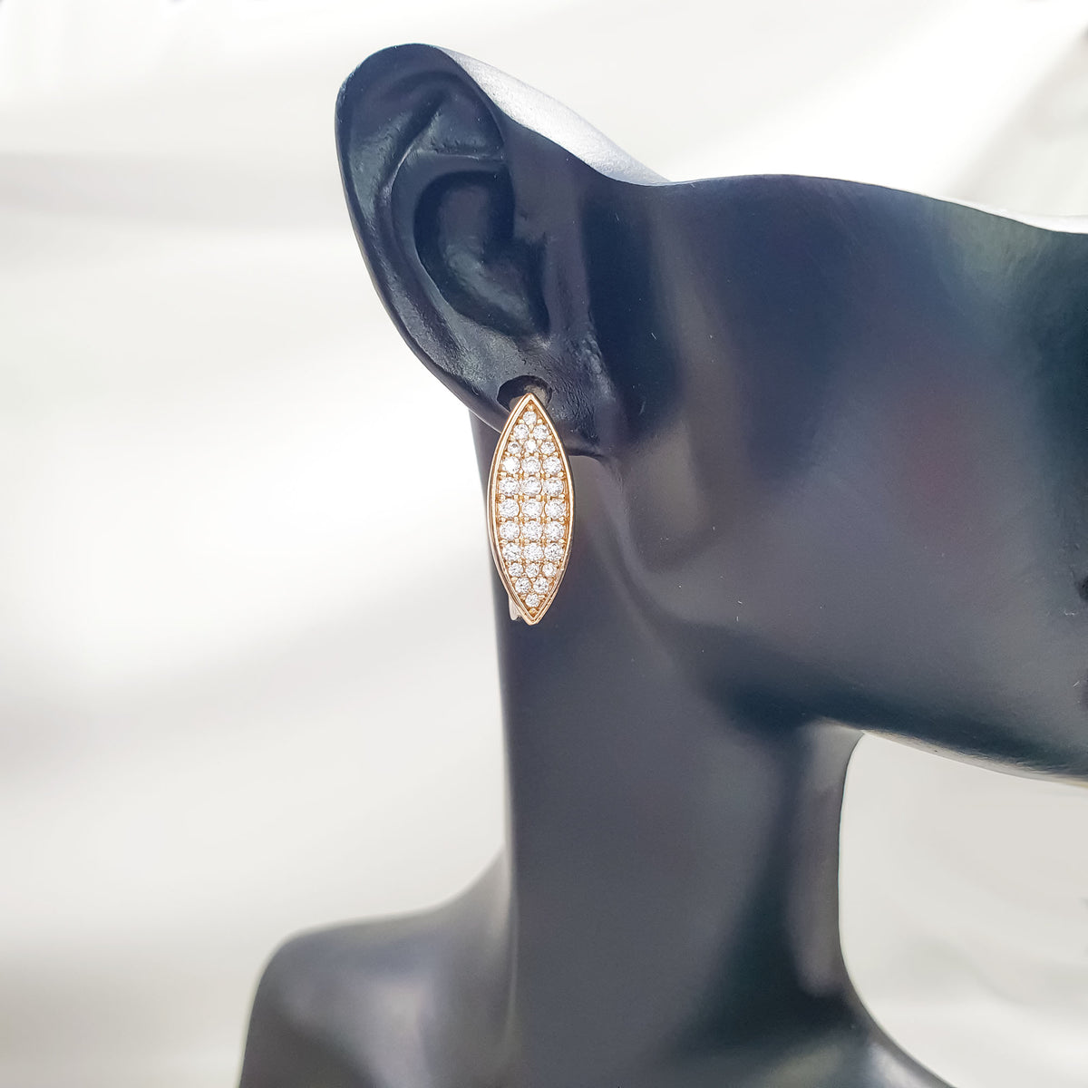Gold-plated earring with clear marquise cubic zirconia on a black ear display