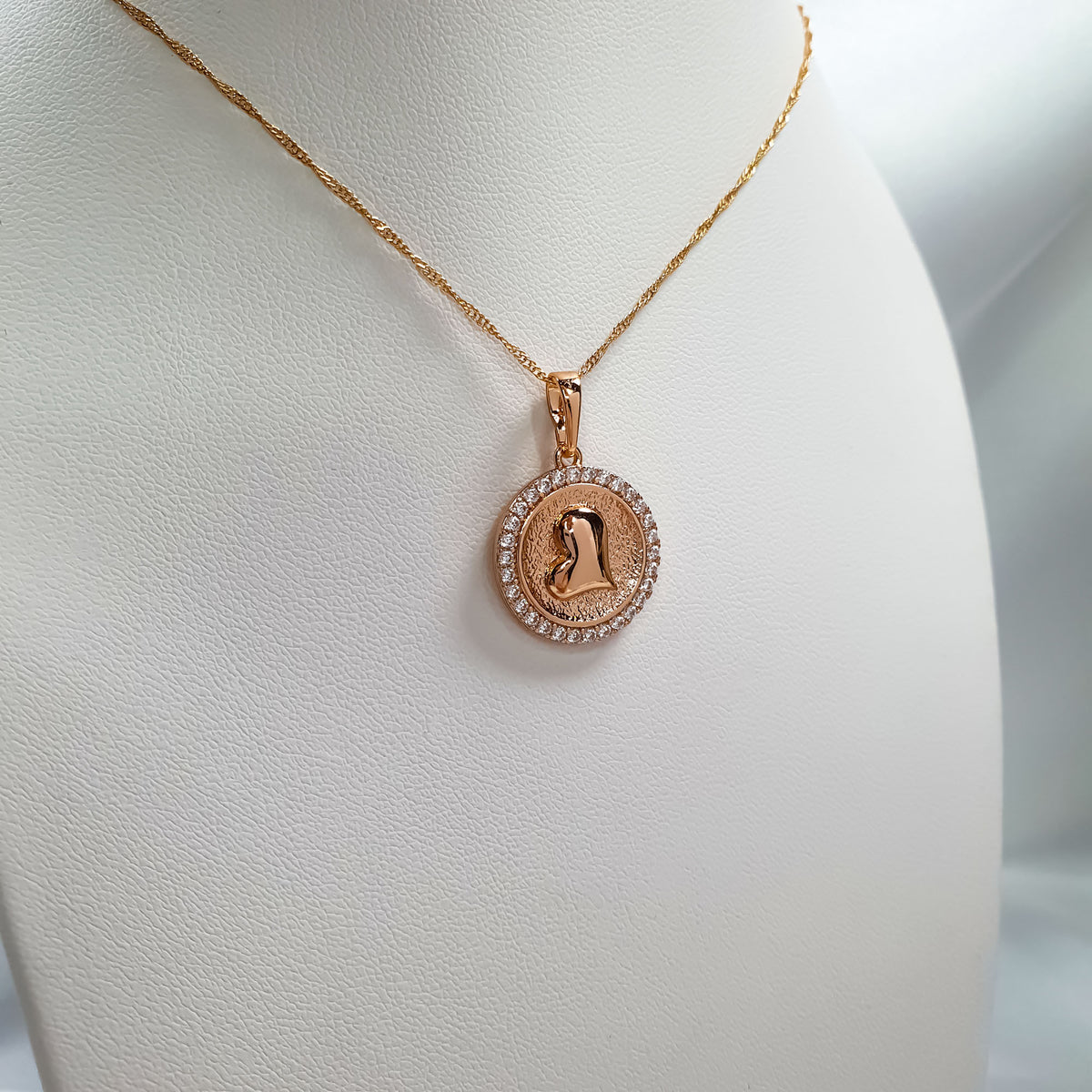 Heart pendant with a cubic zirconia rim on a twisted gold-tone chain