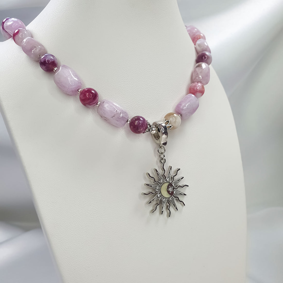 Violet lepidolite necklace on a white mannequin with a silver-tone sun pendant, close-up