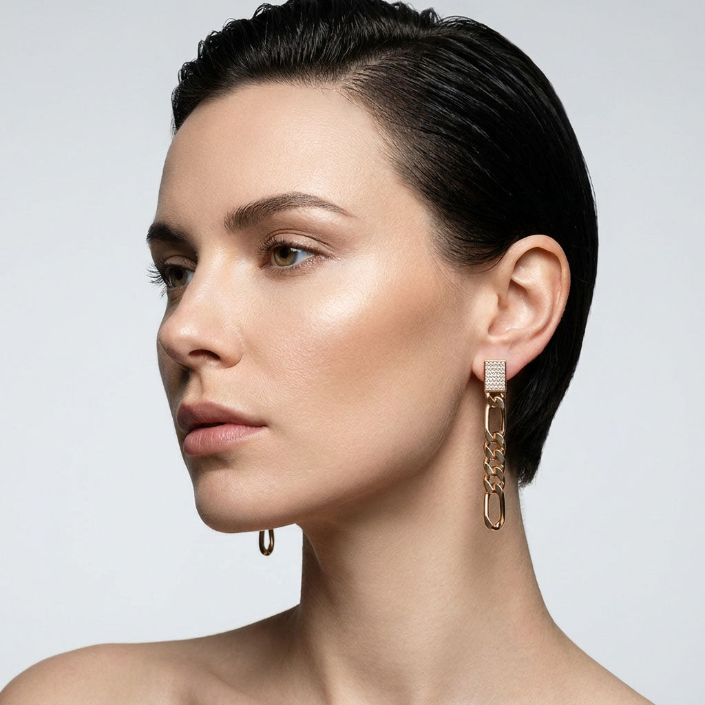 Model in profile wearing a long Figaro chain earring with a stone rectangle