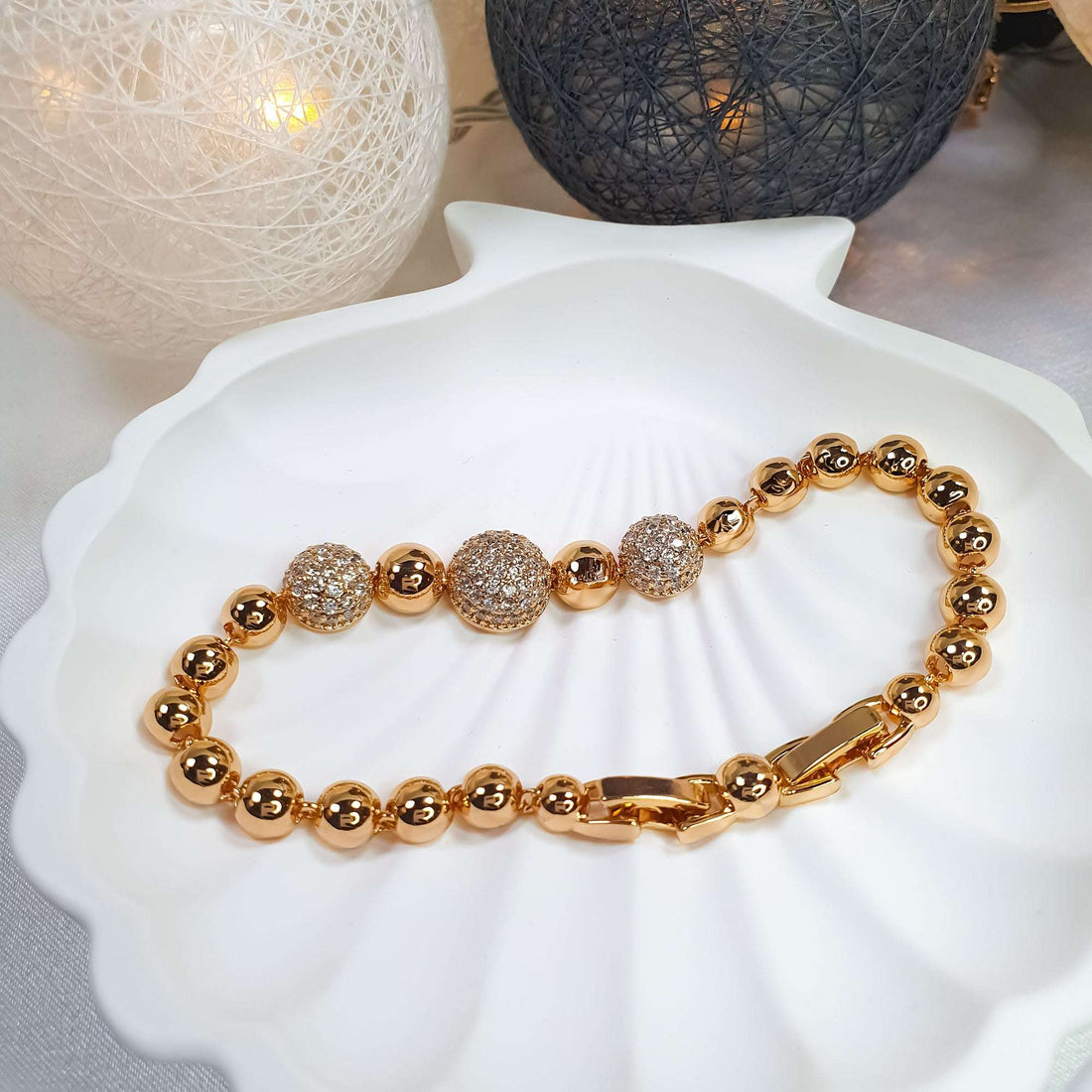 Bead bracelet with sparkling cubic zirconia accents on a white shell dish