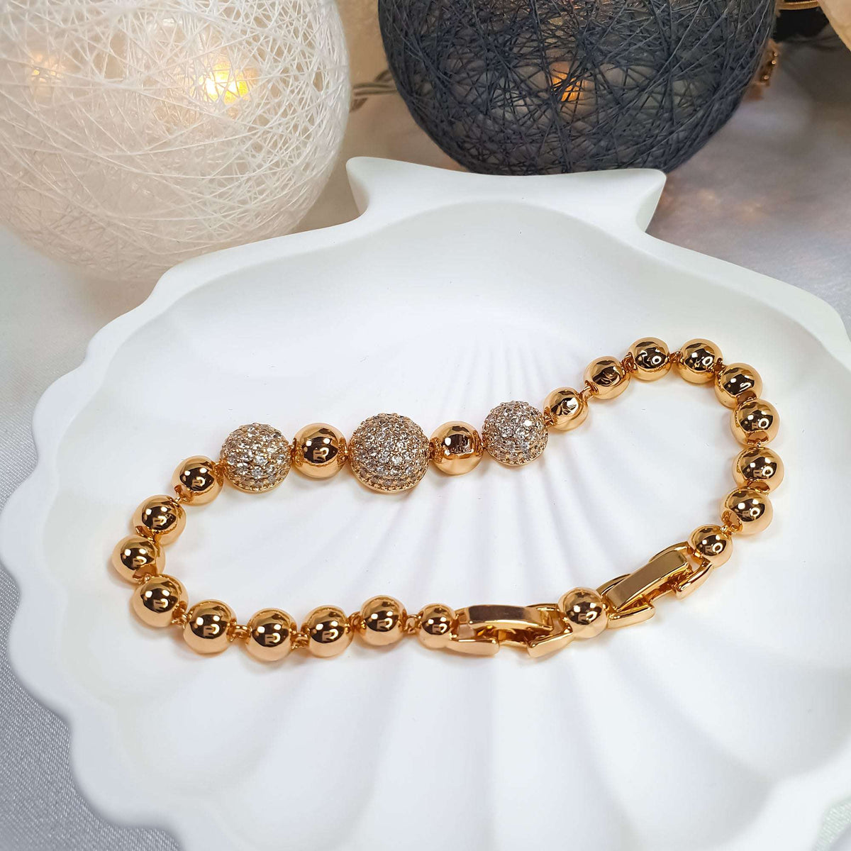 Bead bracelet with sparkling cubic zirconia accents on a white shell dish