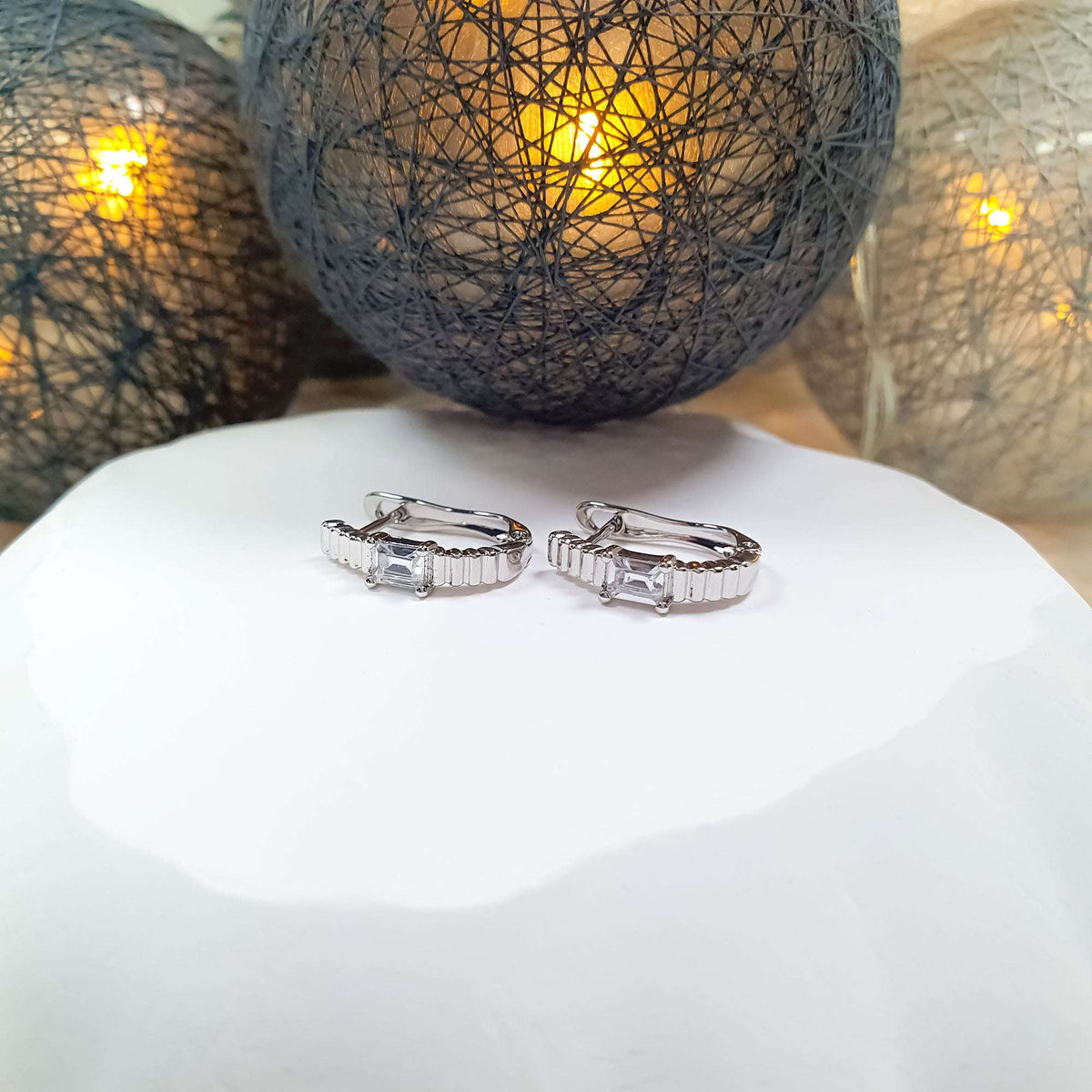 Silver | Silver-tone ribbed earrings from the front, stone in four prongs