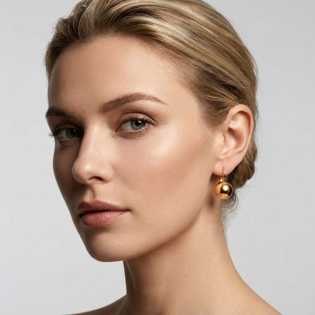 Model wearing a shiny gold-tone ball earring, neat everyday look