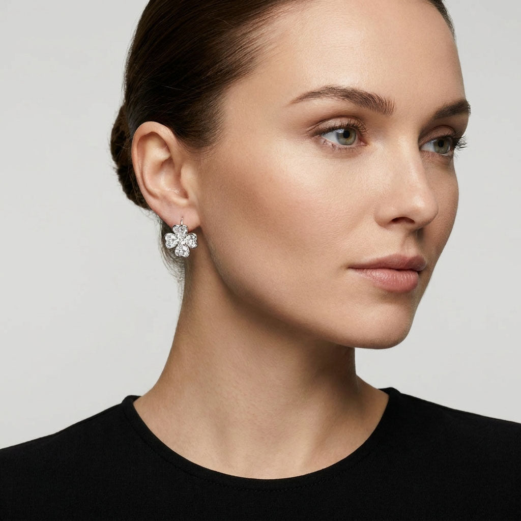 Model in a black blouse wearing a sparkling silver-tone clover earring