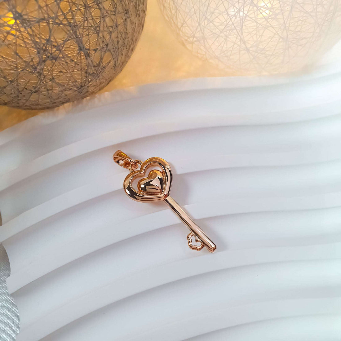 Key pendant with a heart motif on a white wavy surface