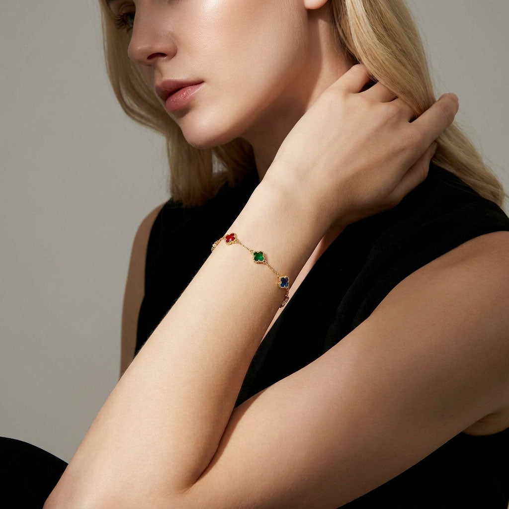 Model wearing a gold-plated bracelet with red, green and blue clover charms