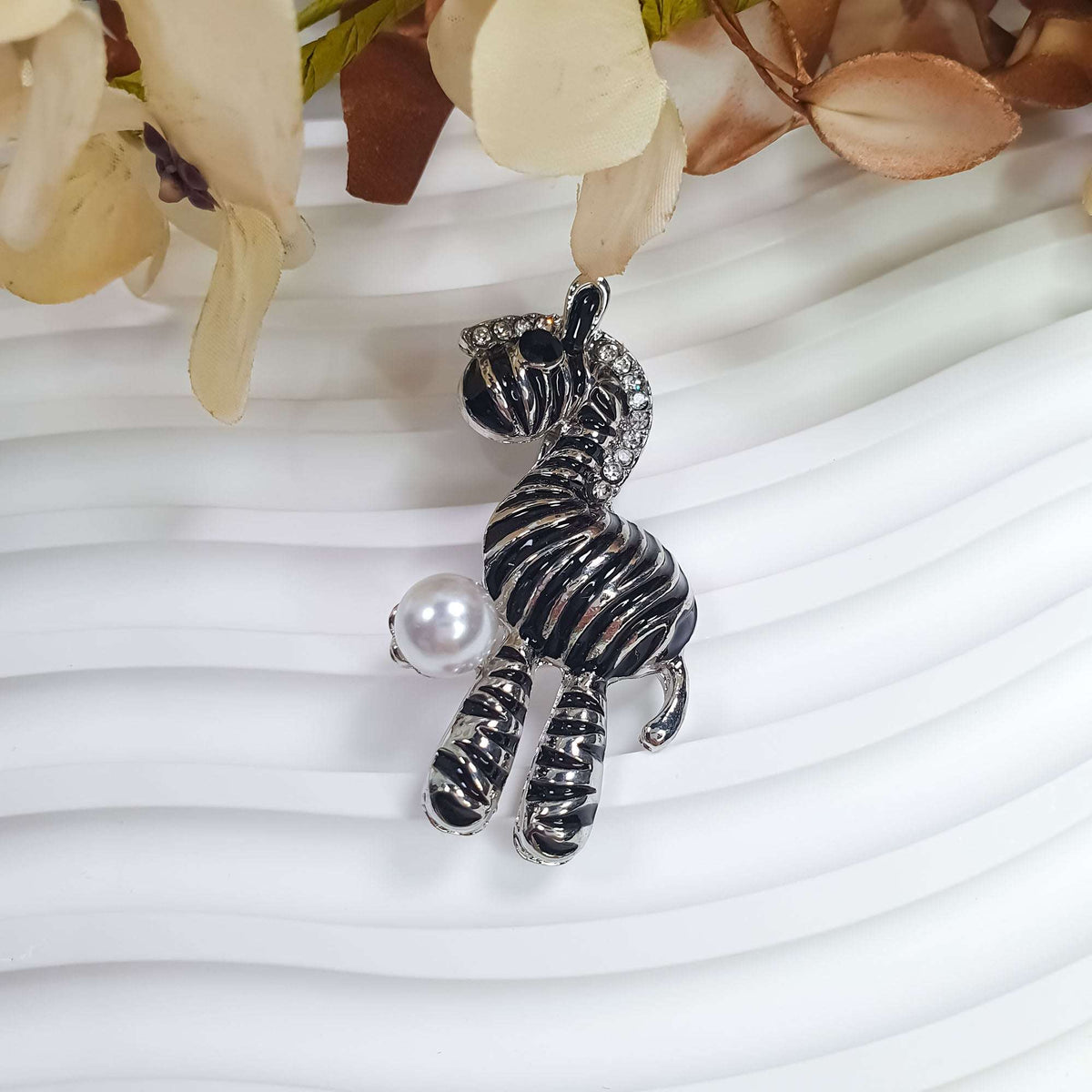 Zebra brooch from the side, clear stones in the mane, white faux pearl