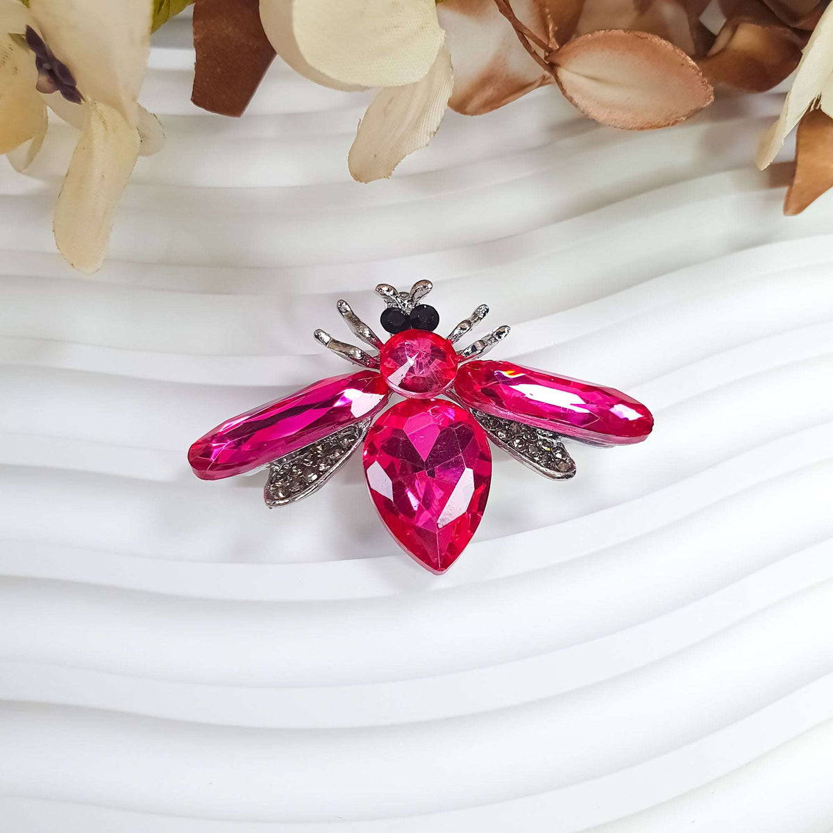 Close-up of pink crystal butterfly, tiny clear stones in wings, black eyes