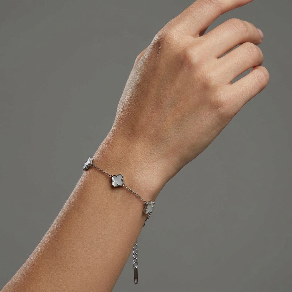 Bracelet with white clovers on a fine silver-tone chain worn on a wrist