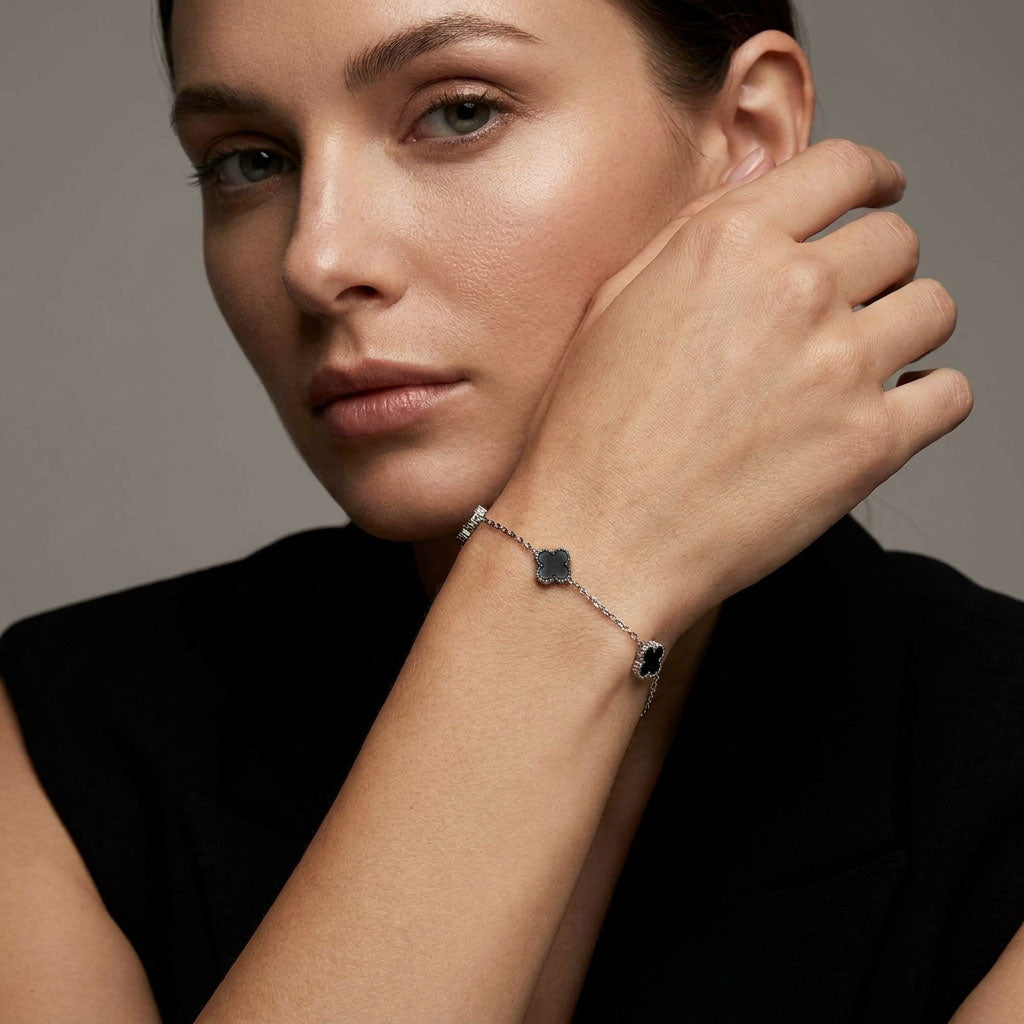 Model in a black top wearing the black clover bracelet on her wrist