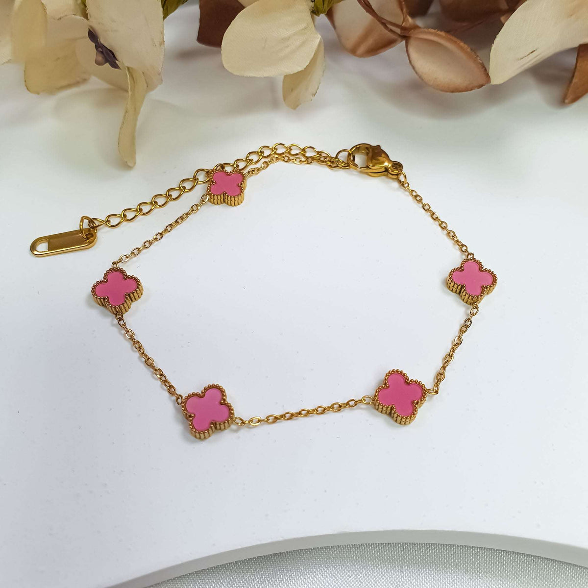 Gold-plated bracelet with pink clovers, a lobster clasp and an extension chain