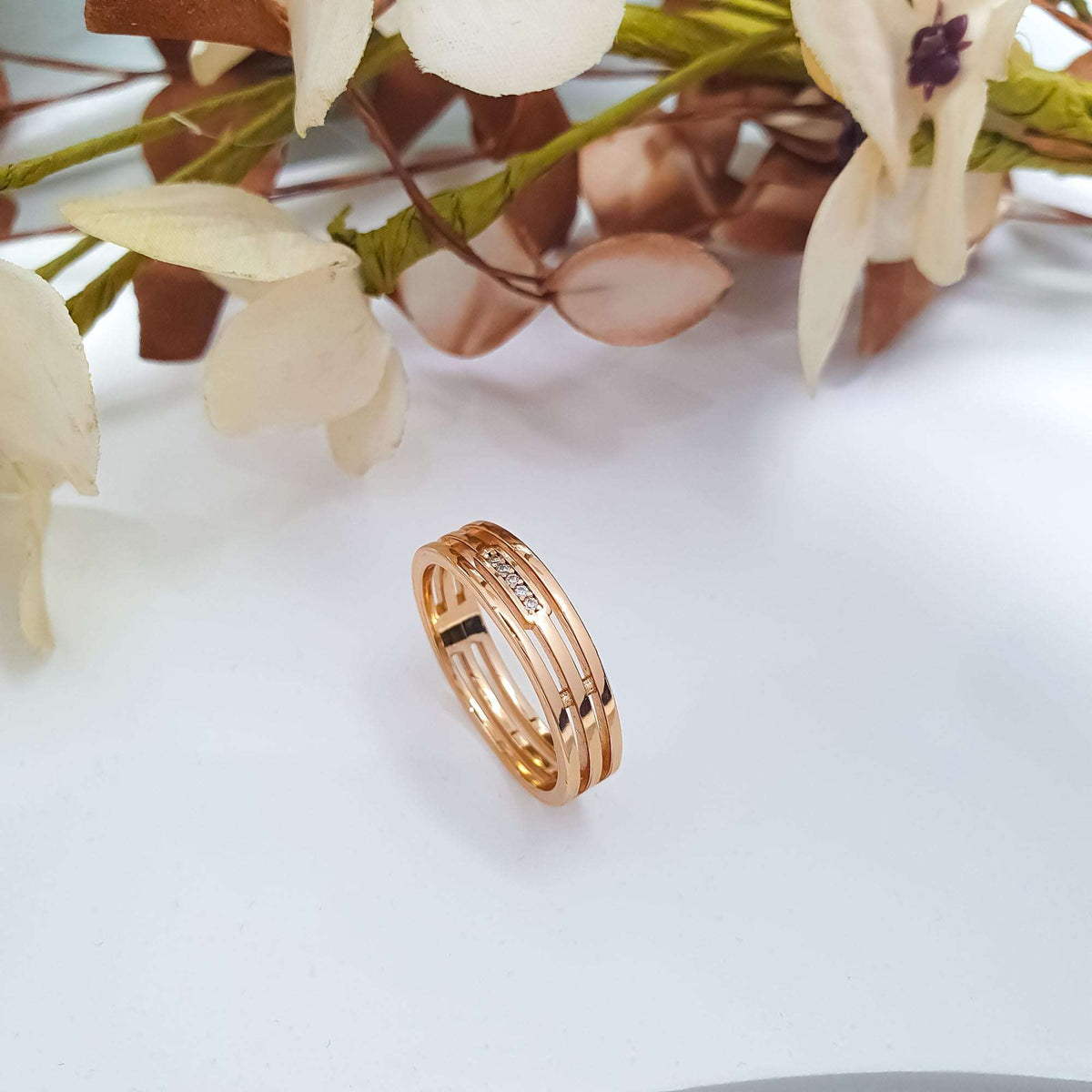 Gold-tone ring with an open side pattern and a zirconia row among flowers
