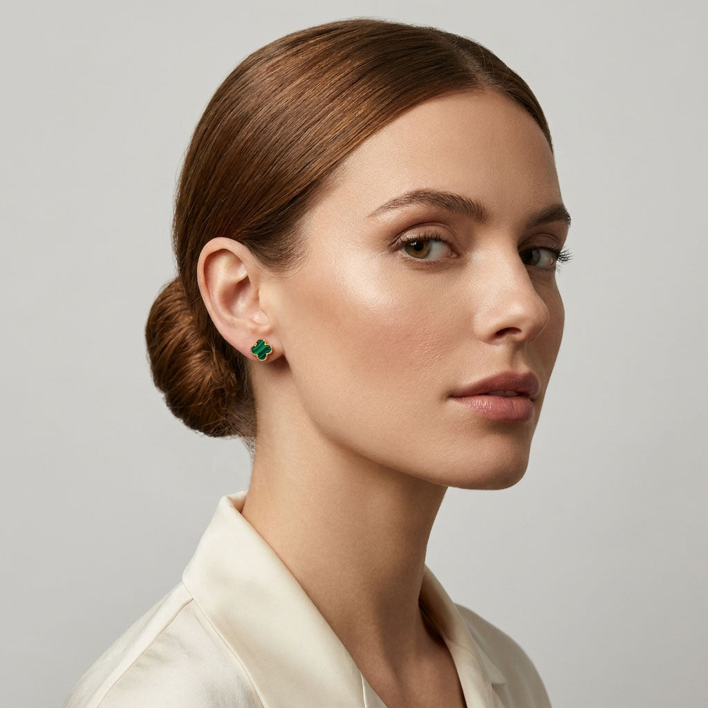 Model in profile wearing a small green enamel clover stud with gold-tone rim