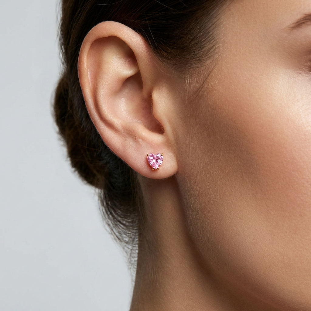 Pink cubic zirconia heart stud worn in a model's ear