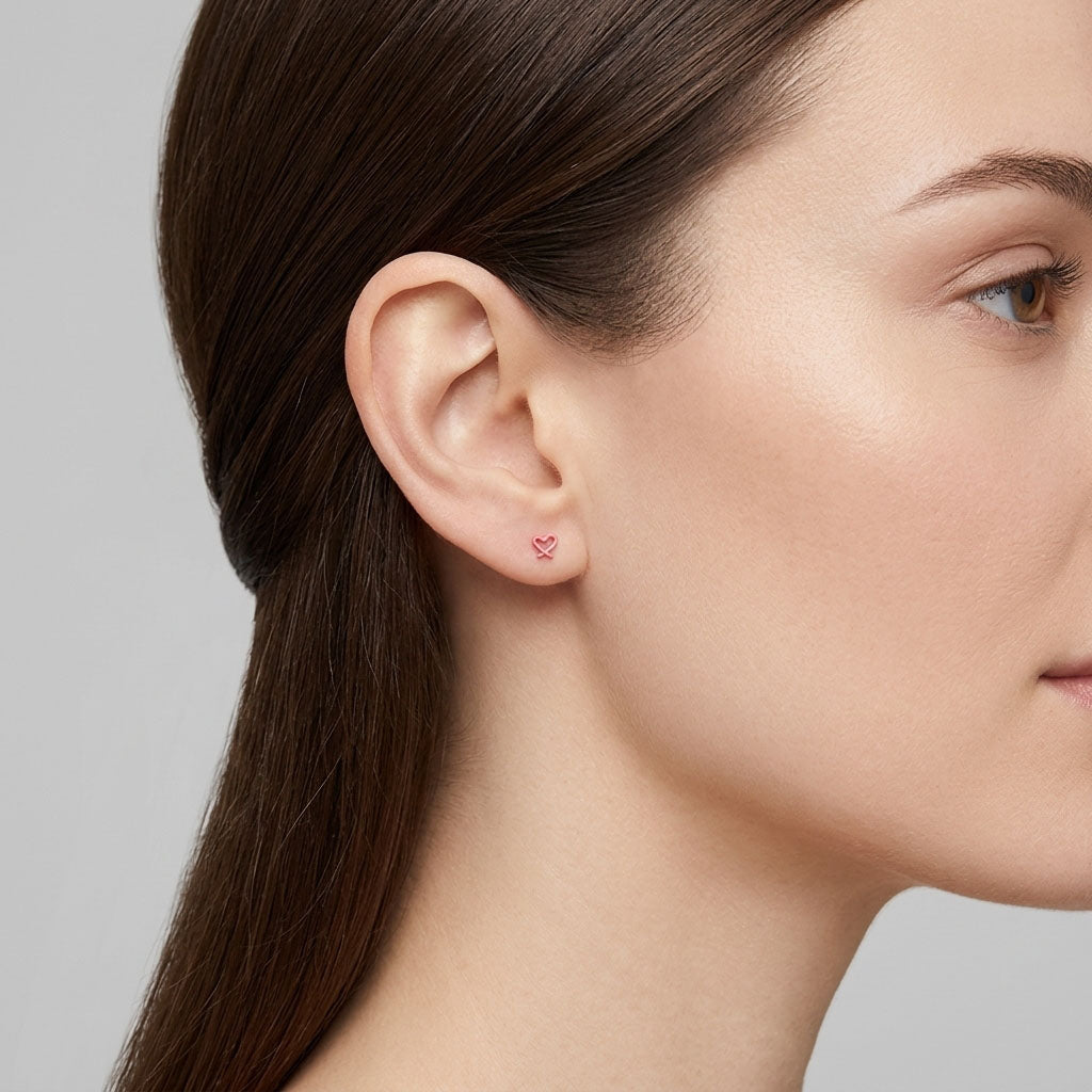 Close-up of a tiny red enamel heart stud on a model's ear