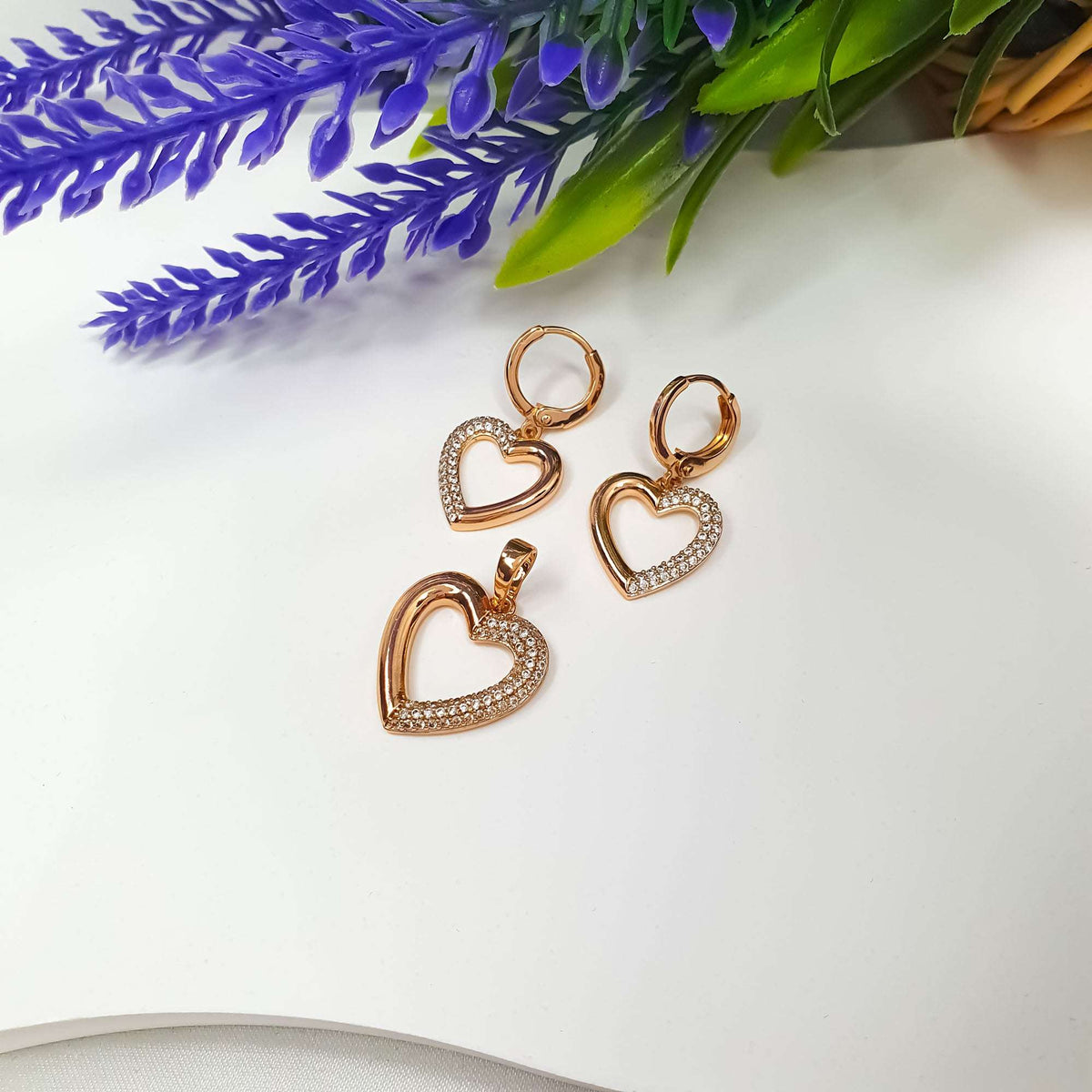 Gold-tone heart earrings and pendant beside purple lavender