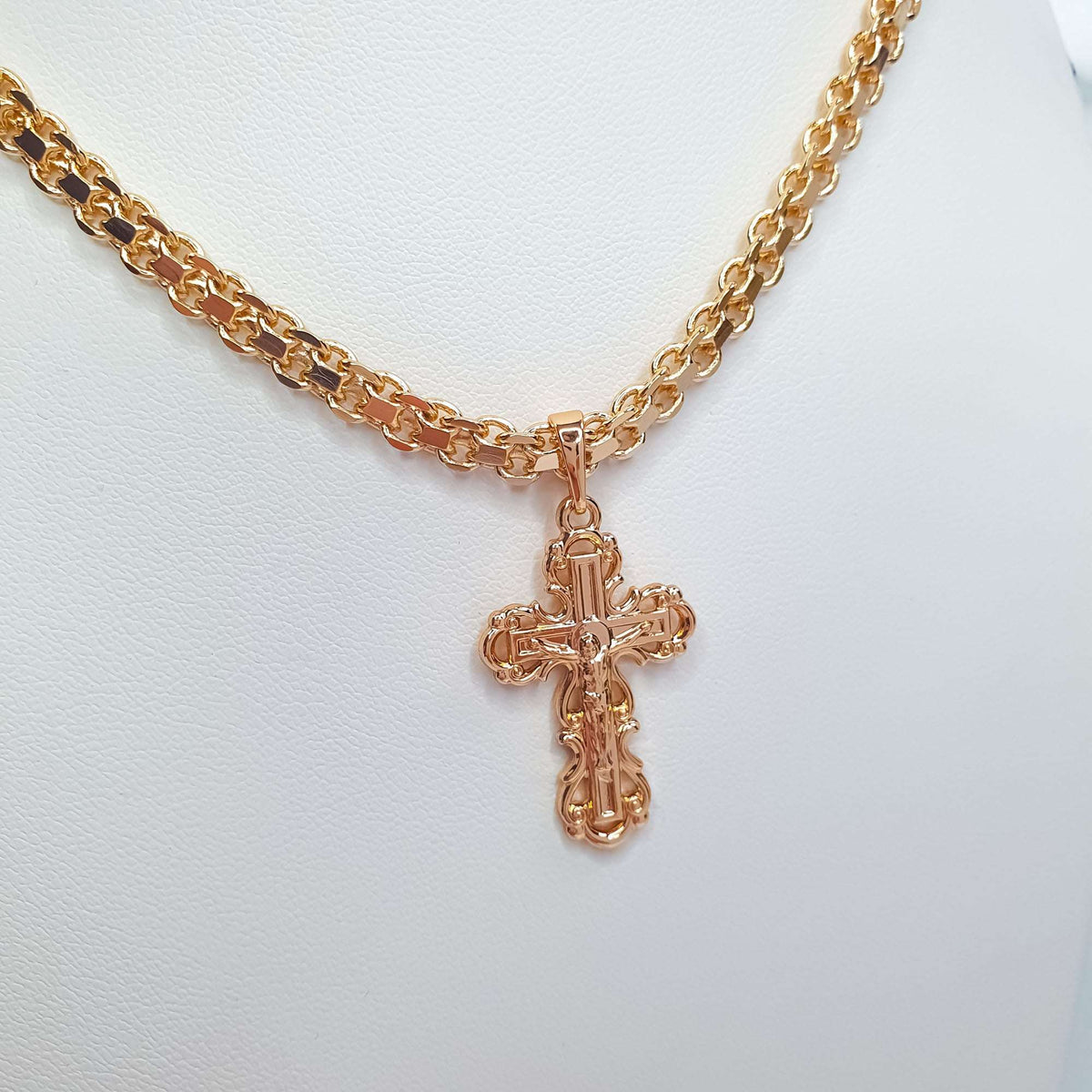 Ornate gold-plated Orthodox cross hanging from a thick link chain