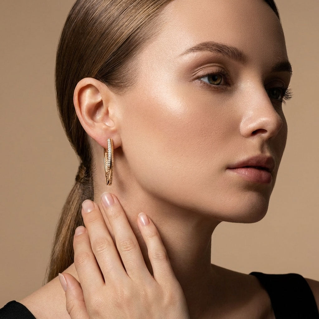 Woman wearing a long gold-tone earring with a sparkling line of cubic zirconia