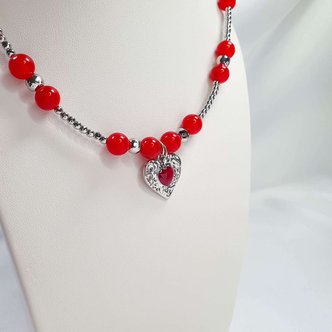 Red bead necklace on a mannequin, heart pendant with a red stone centre