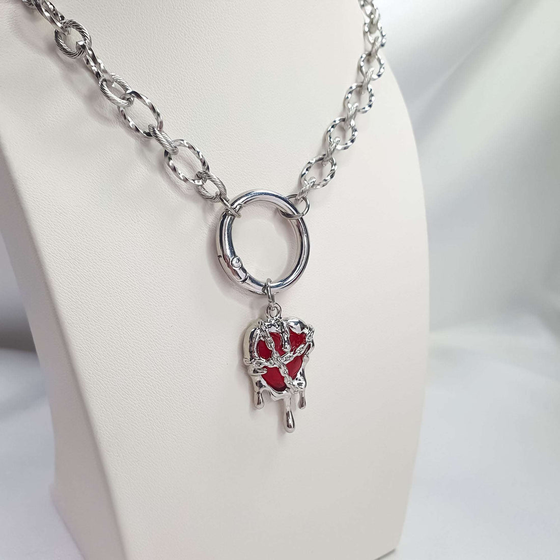Chunky chain with a front ring clasp and red heart in a melted-metal frame