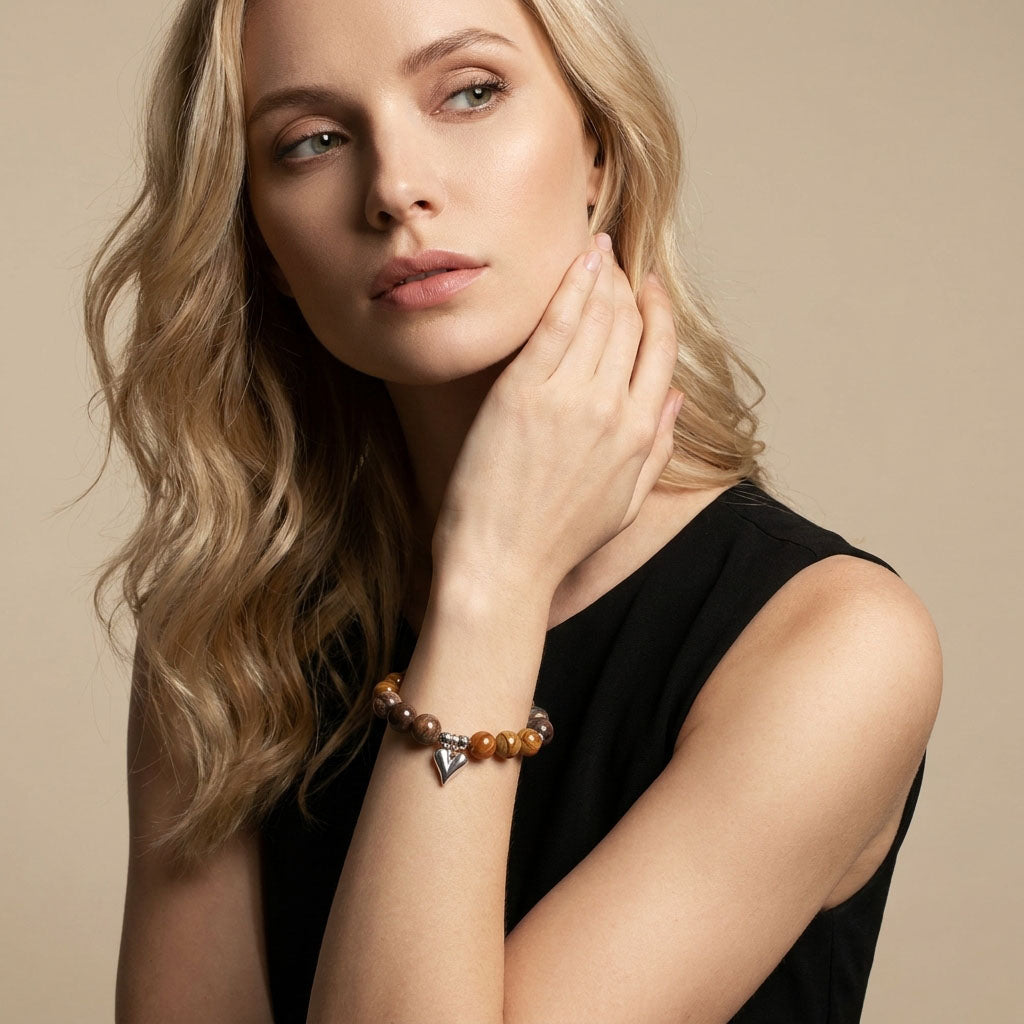 Model wearing a brown stone bead bracelet with a silver-tone heart