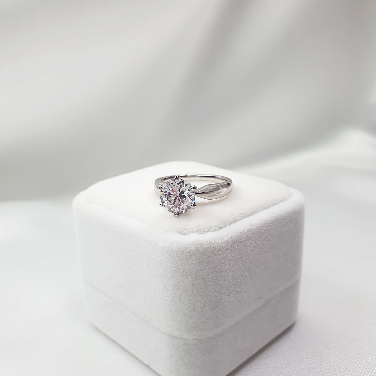 Platinum-plated solitaire ring with a large round cubic zirconia on a velvet box