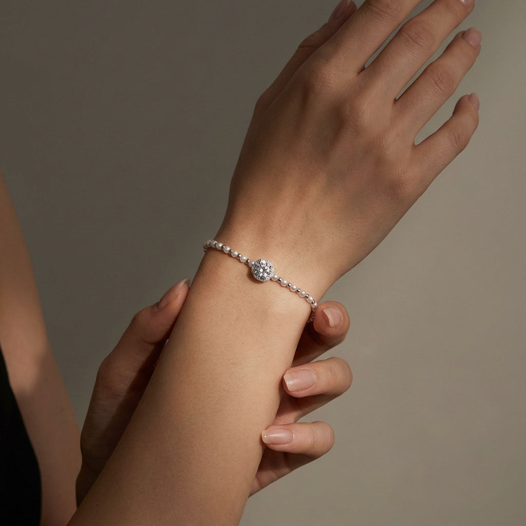 Woman wearing a delicate pearl bracelet with a sparkling cubic zirconia accent