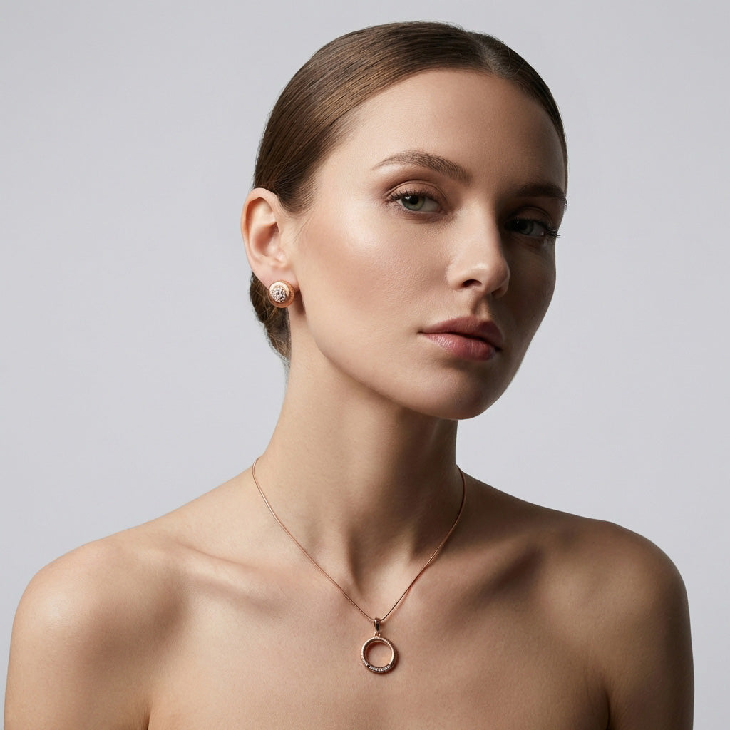 Model wearing ribbed round earrings and a ring pendant in warm gold tone