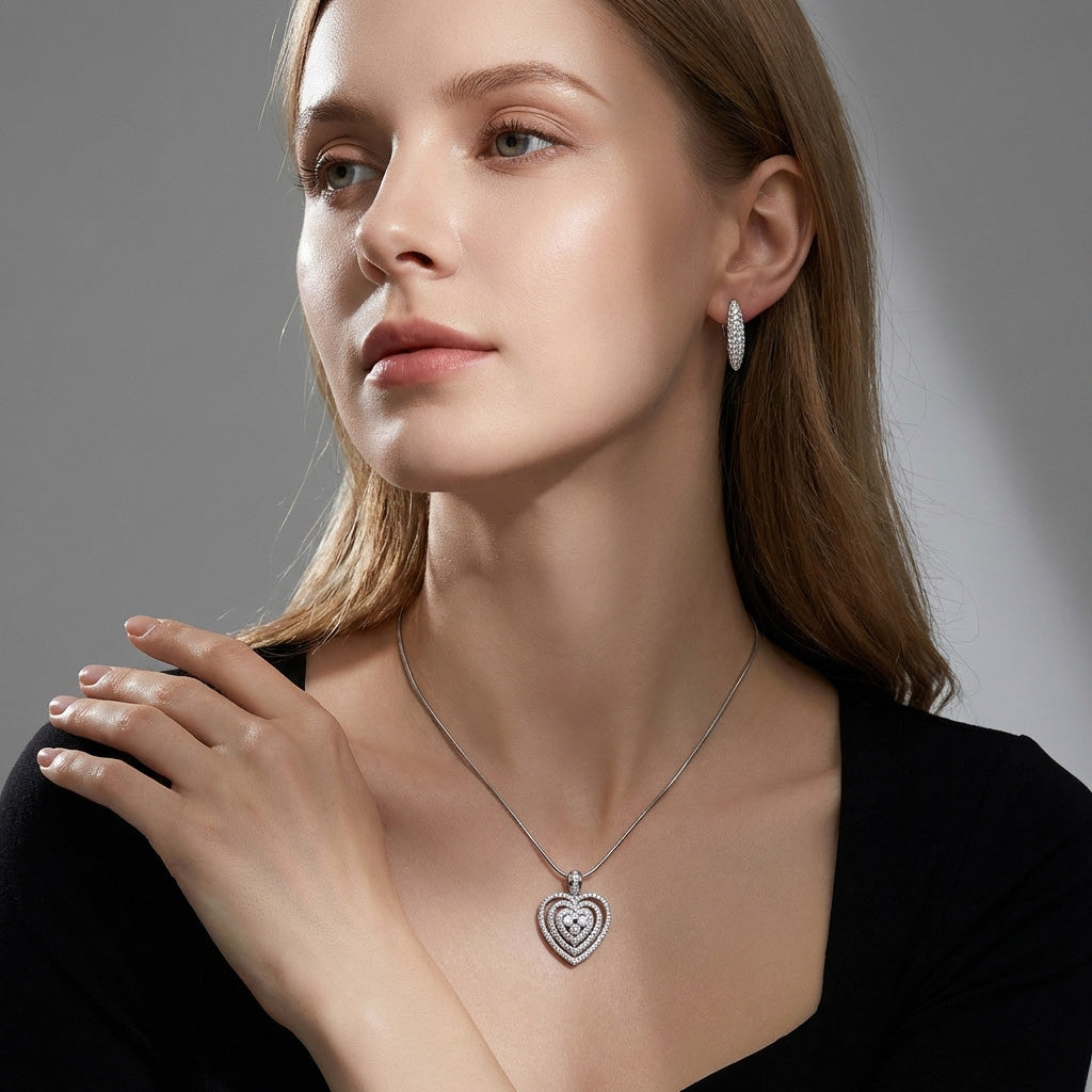 Model in a black blouse wearing a heart pendant and sparkling earrings