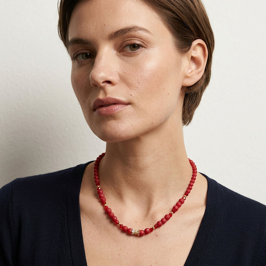 Elegant women's necklace with red stones and a sparkling gold-tone accent